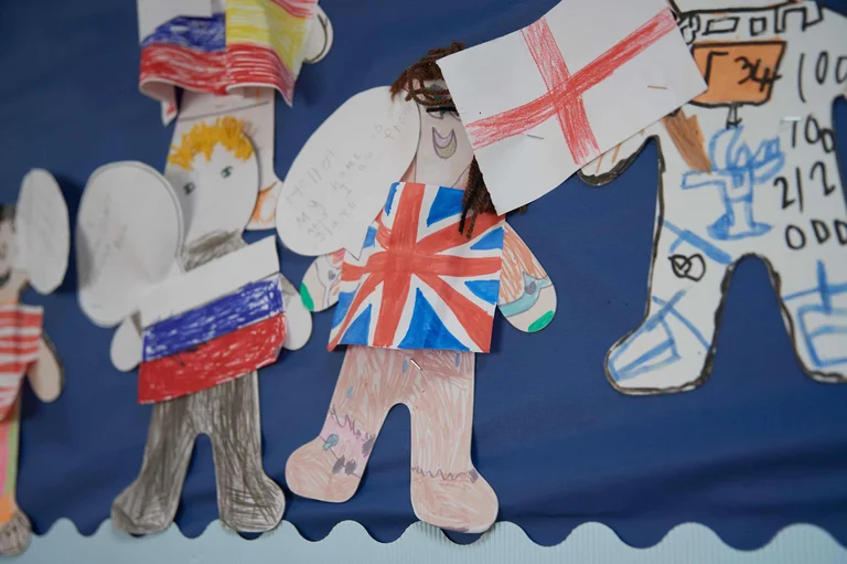 Cut-out drawings in the shape of people with flags on them 