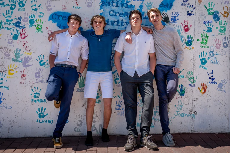 Four students in front of a wall 