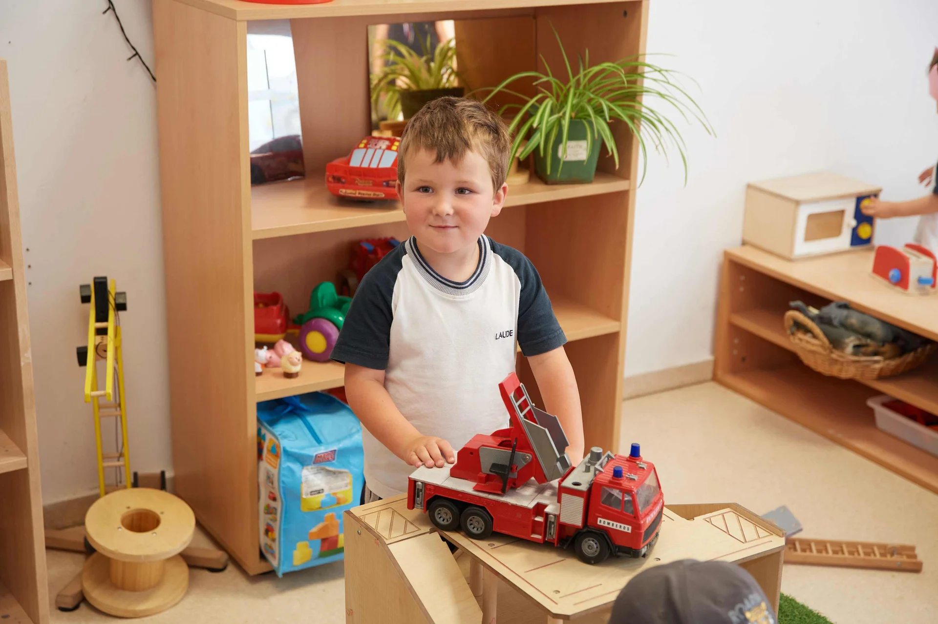 Pre school child playing with toy fire truck