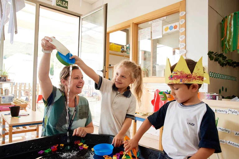 Primary school students playing with teacher 