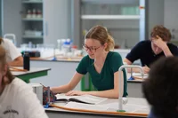 Sixth form students reading a book in the classroom