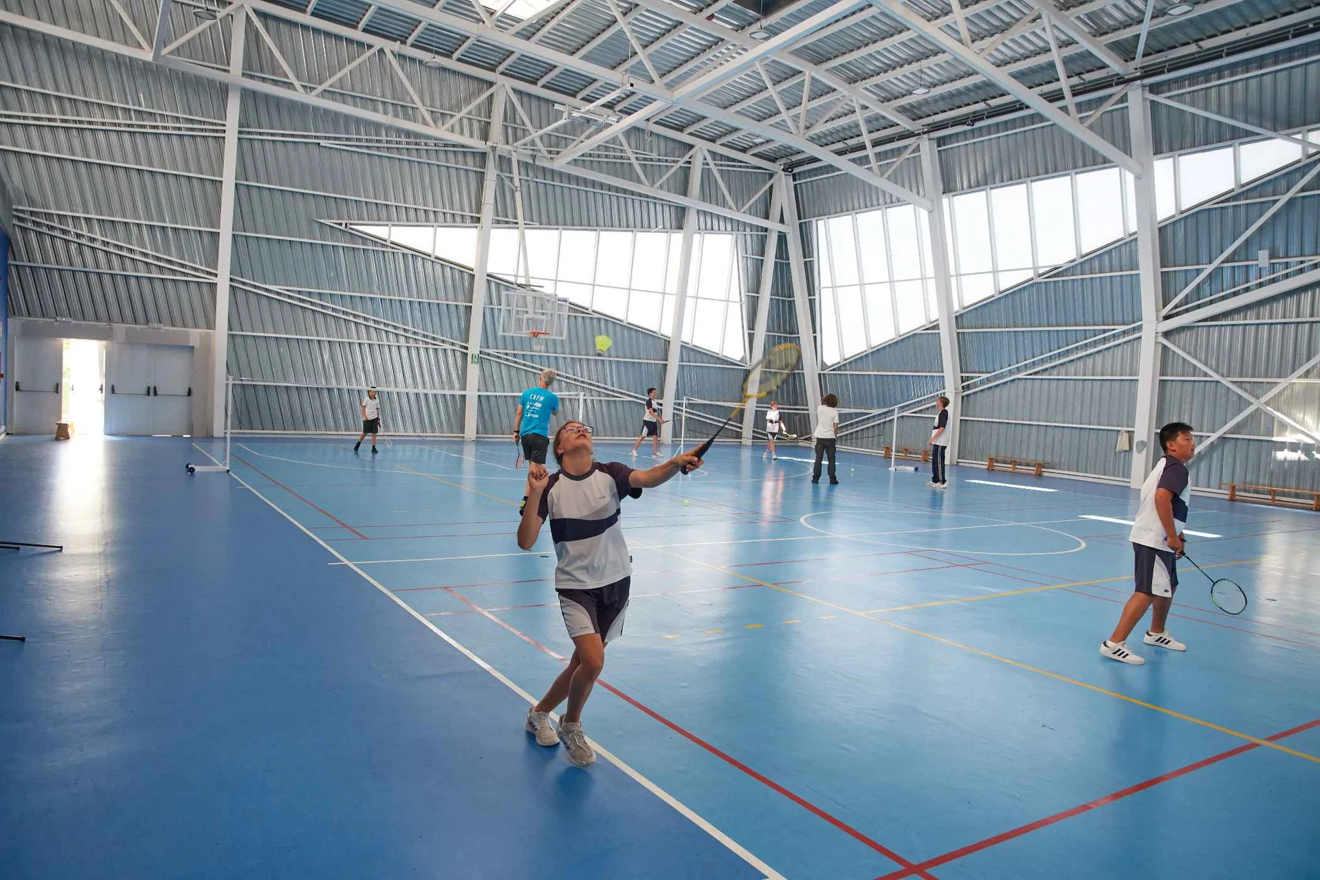 Students play badminton in the school gymnasium 